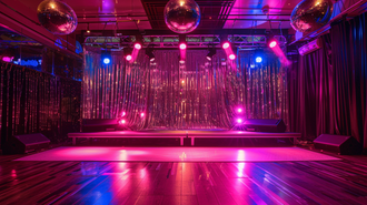 A stage setup with glittering disco balls and vibrant lights for a 70s theme party.