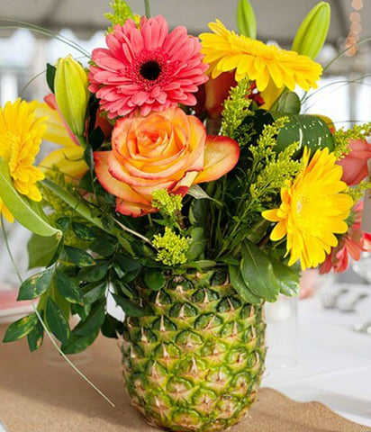 Pineapple vase centerpiece with colorful flowers