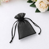 Black organza drawstring gift pouch on white background with flowers