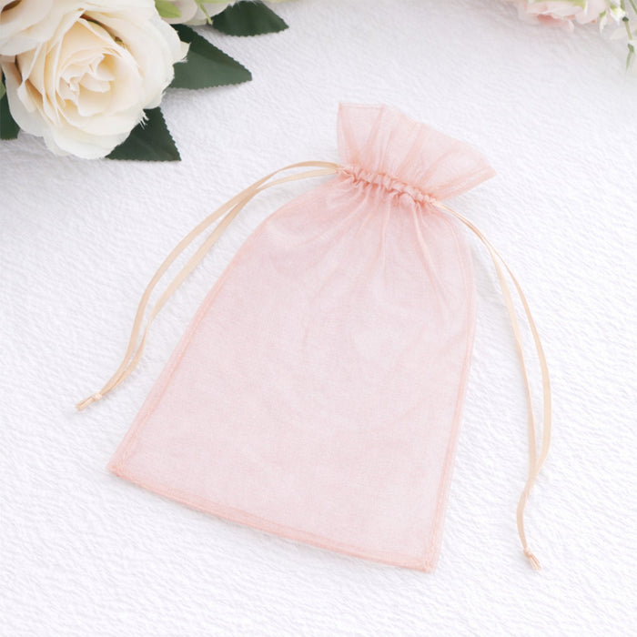 Peach organza gift bag with drawstring closure on a white background
