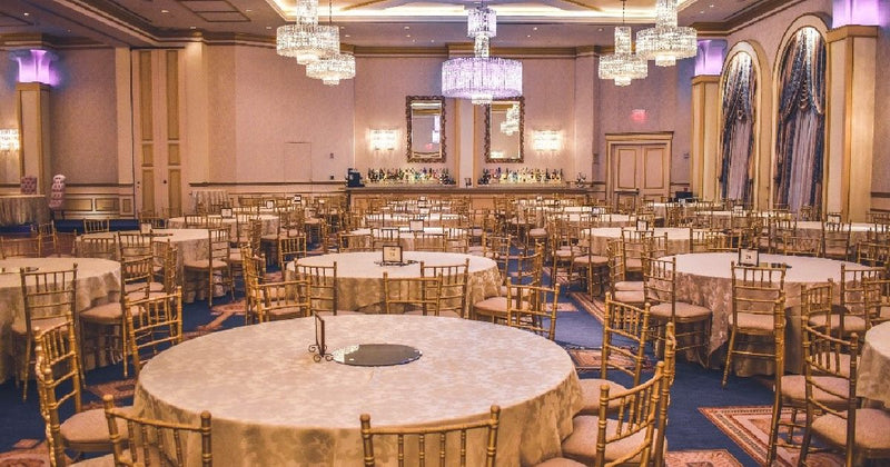 Ballroom reception with gold chairs and chandelier lighting