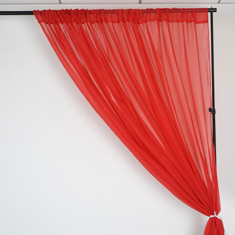 Red sheer curtain panel tied back on a stand