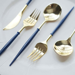Gold and blue cutlery set on a white plate