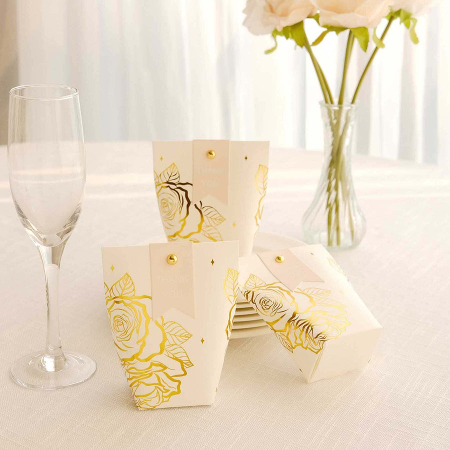 Elegant white gift boxes with gold rose design on a table setting.