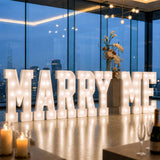 Illuminated “Marry Me” wedding proposal sign in modern rooftop venue