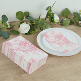 Pink floral patterned napkins in a box, styled with a plate and greenery.