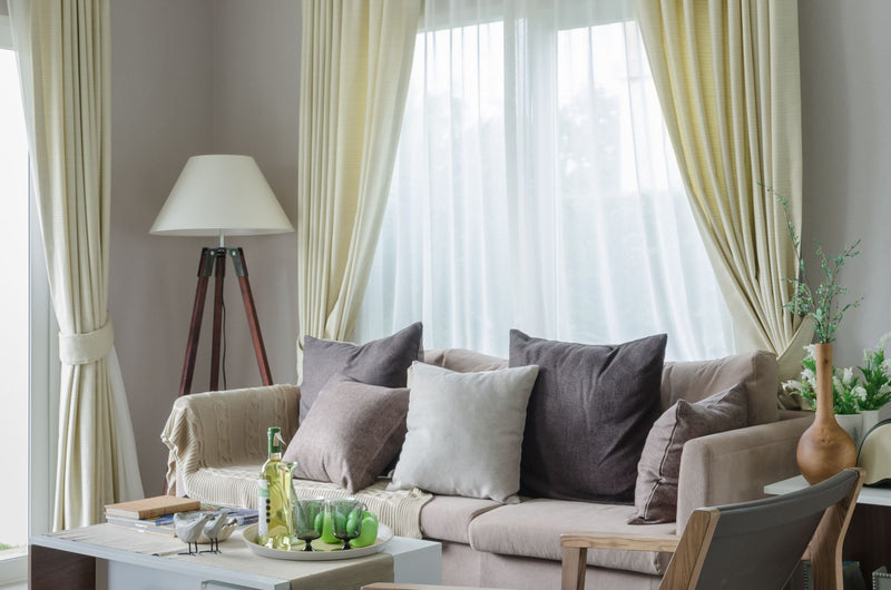 Cozy living room with beige sofa and white curtains