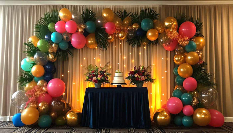 Tropical balloon garland framing a cake table