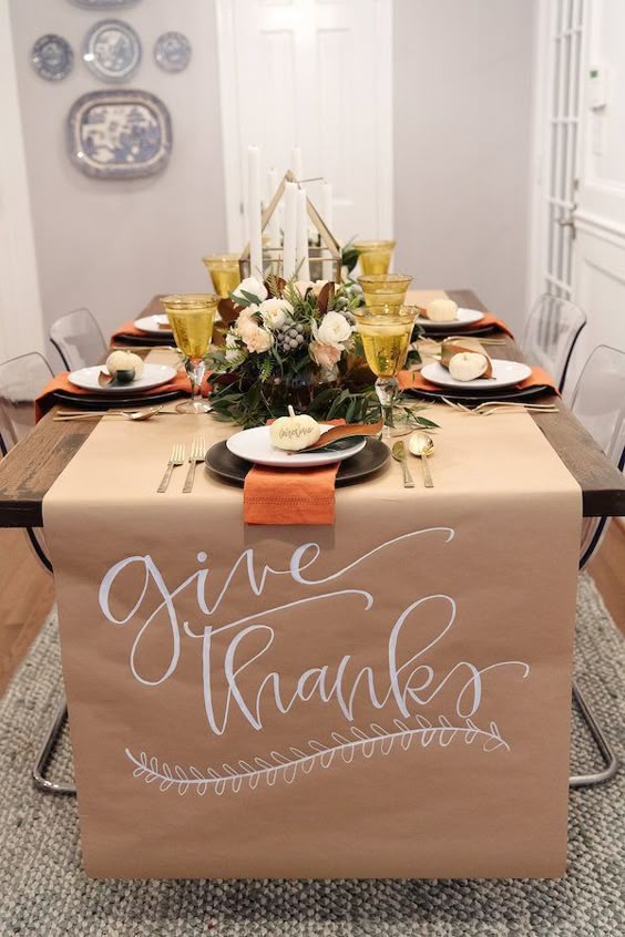 Thanksgiving table setting with gold glasses and floral centerpiece