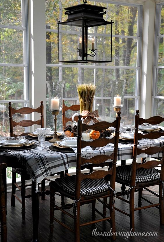 Fall dining table with plaid runner, candles, and pumpkins
