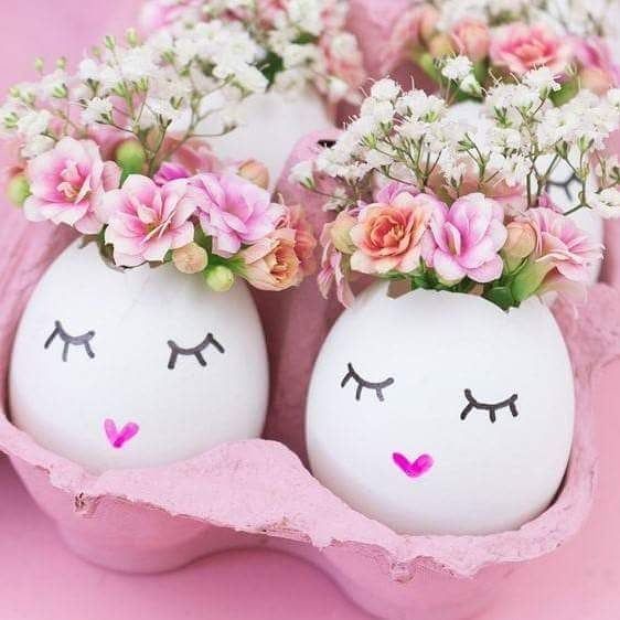Painted Easter egg vases with pink flowers in a carton