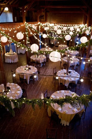 Outdoor reception with hanging lanterns and round tables