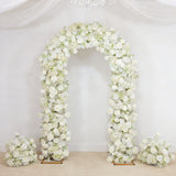 White floral wedding arch with rose arrangements on a draped backdrop