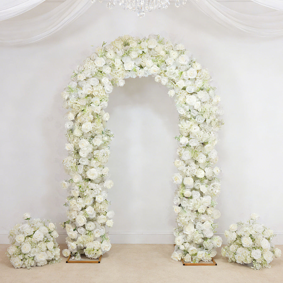 White floral wedding arch with rose arrangements on a draped backdrop