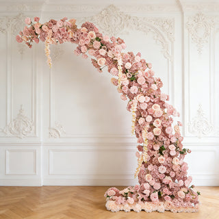 Floral arch arrangement in soft pink tones against a light background.