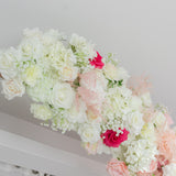 Artificial floral arrangement with roses and hydrangeas in pastel colors.