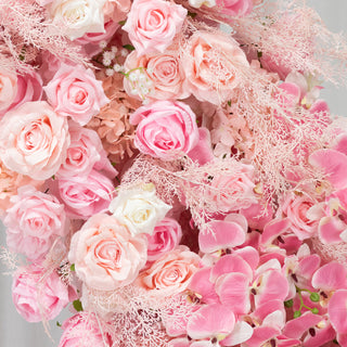 Pink floral arrangement with roses and orchids in various shades.
