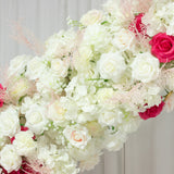 Floral arrangement with white, pink, and cream roses and greenery.