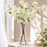 Elegant white floral arrangement in a glass vase on a sunlit table