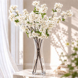 White blossom arrangement in a clear glass vase in a sunlit room