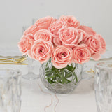 Pink roses in a crystal vase on a dining table.