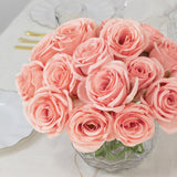 Pink roses bouquet in a clear vase on a light table setting.