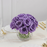 Purple rose bouquet in a clear vase on a table setting.