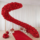 Red floral crescent arch with rose-covered wedding aisle decor