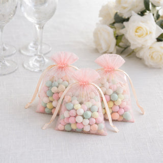 Pastel candy favor bags with tulle on a white wedding table
