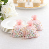 Pastel candy favor bags on white plates with rose decoration