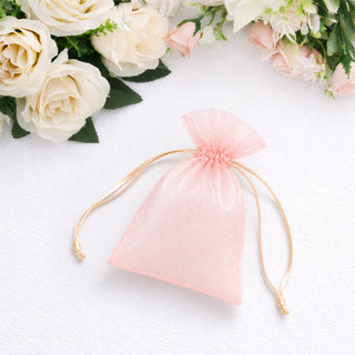 Pink organza drawstring gift bag with white roses on a soft background