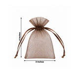 Brown sheer organza gift pouch with ribbon ties on white floral background
