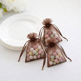 Pastel candy in brown organza gift bags beside white plates