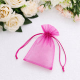 Pink organza gift pouch on white background with flowers
