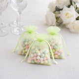 Pastel candy gift bags with organza drawstrings on a white table setting