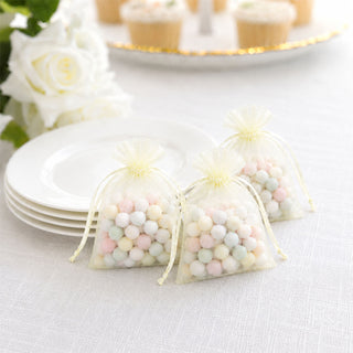 Pastel candy favor bags with white plates and cupcake party decor