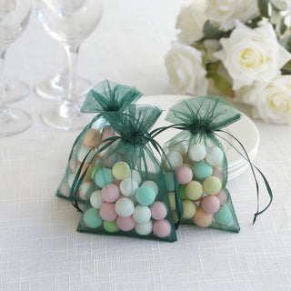 Colorful decorative candy bags in green mesh on a table with white roses.