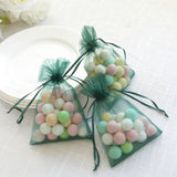 Colorful decorative candy bags tied with green ribbons on a table.