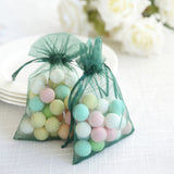 Colorful decorative balls in sheer green bags on a table.