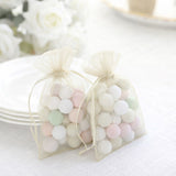 Two sheer bags filled with pastel-colored candies on a table.
