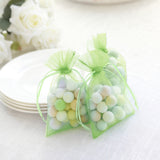 Colorful pastel candy bags on a table with white plates.