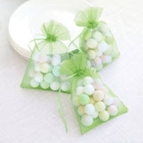 Colorful candy-filled favor bags in sheer green mesh.