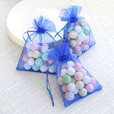Colorful pastel candy-filled bags on a white tablecloth.