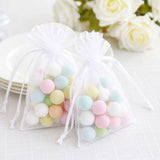 Pastel candy balls in white organza gift bags with ribbon drawstring