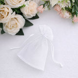 White organza drawstring gift bag on soft white fabric with floral border