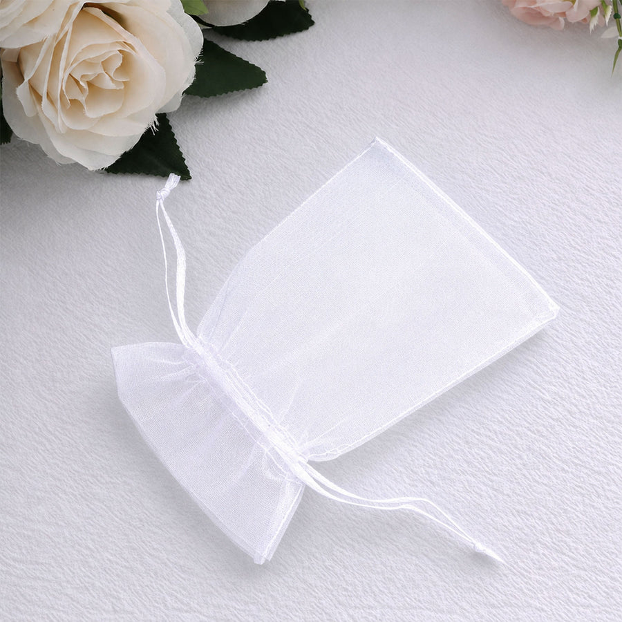 White organza gift pouch with drawstring on soft fabric with roses