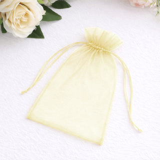 Yellow organza drawstring bag on a plain white background