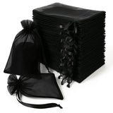Black organza gift bags stacked with various sizes, perfect for packaging and favors.