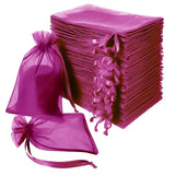Stack of pink organza gift bags with drawstrings on a white background.