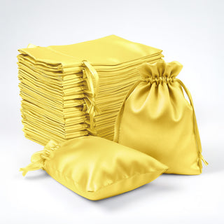 Yellow satin drawstring bags stacked and displayed in various sizes.